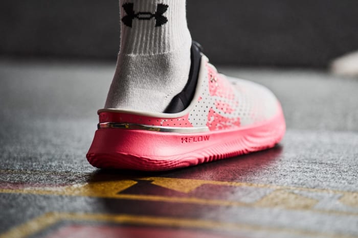 Rear view of pink and white Under Armour shoe.